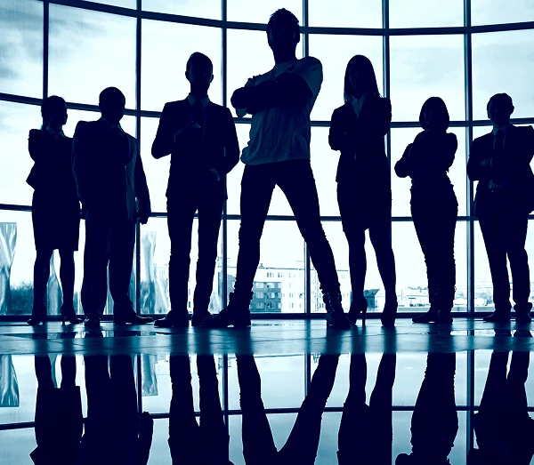 Silhouette of a successful business team looking out a modern office window